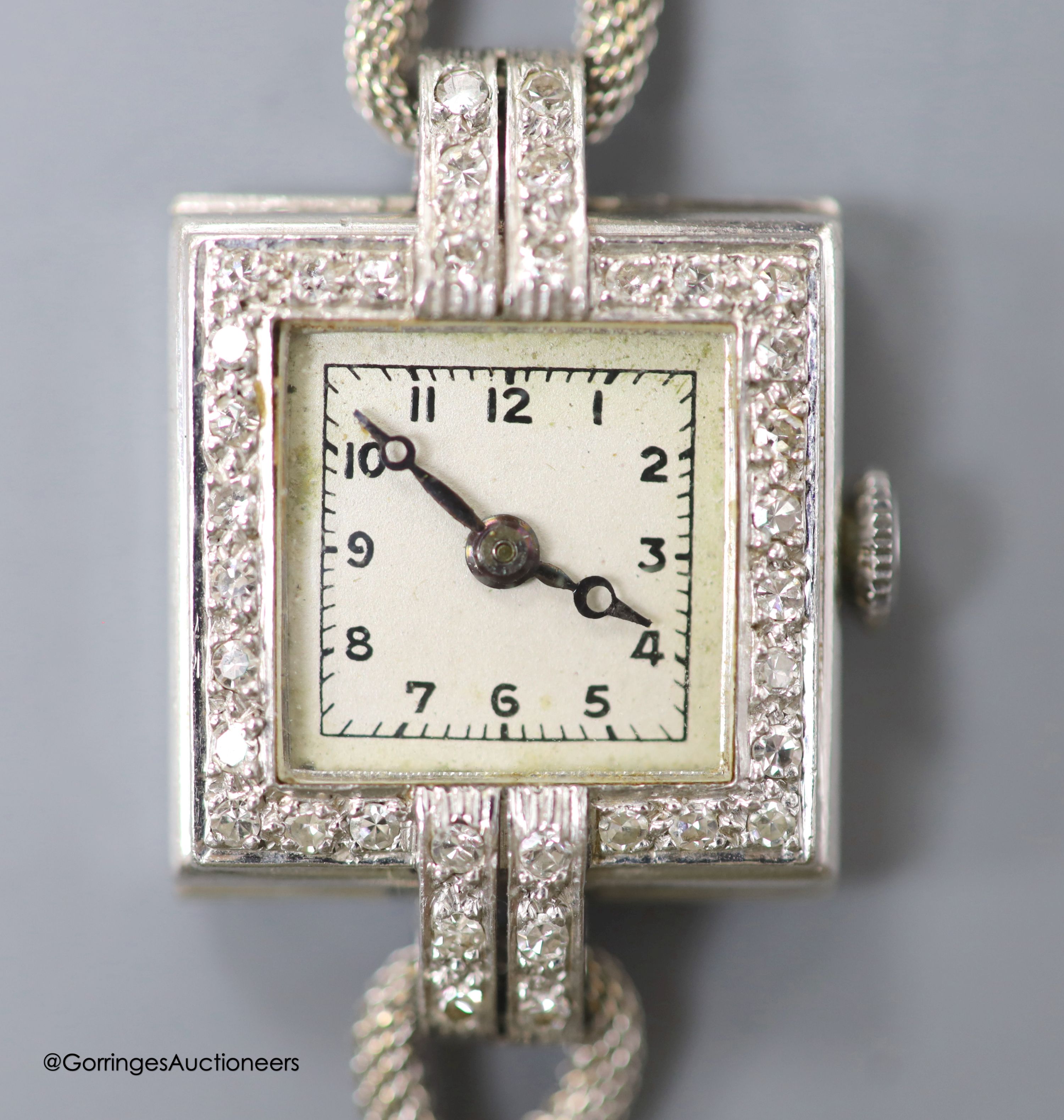 A lady's 1940's white metal (stamped platinum) and diamond set Vertex manual wind square dial cocktail watch, on a 9ct twin strand bracelet